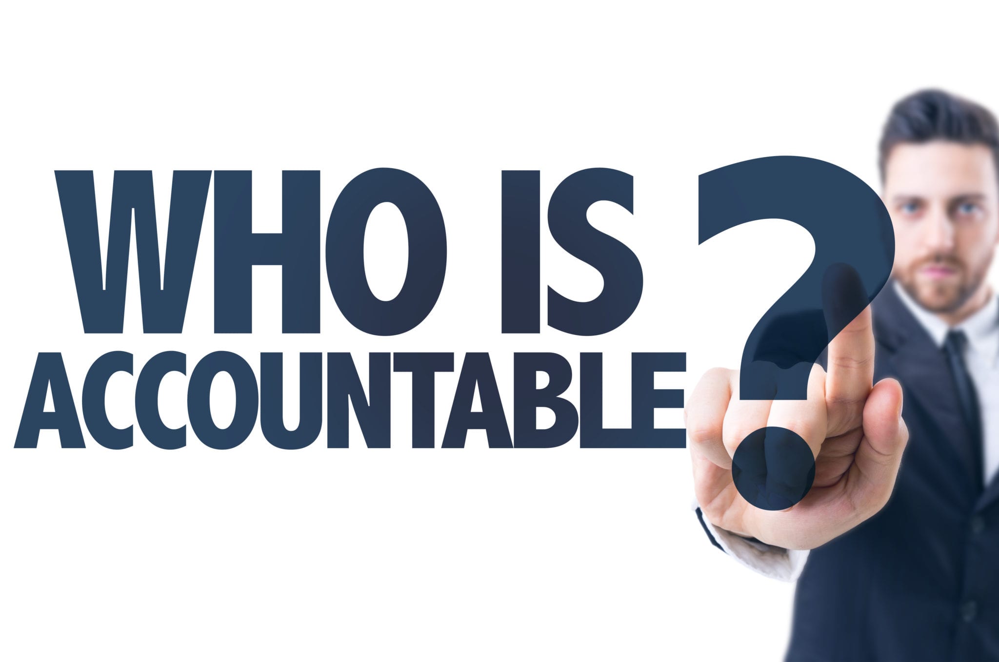 A man in a dark suit in front of a white background holding up his pointer finger with the title, " Who is accountable?"