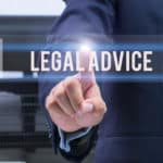 A man in a business suite touching the word legal advice in the foreground.