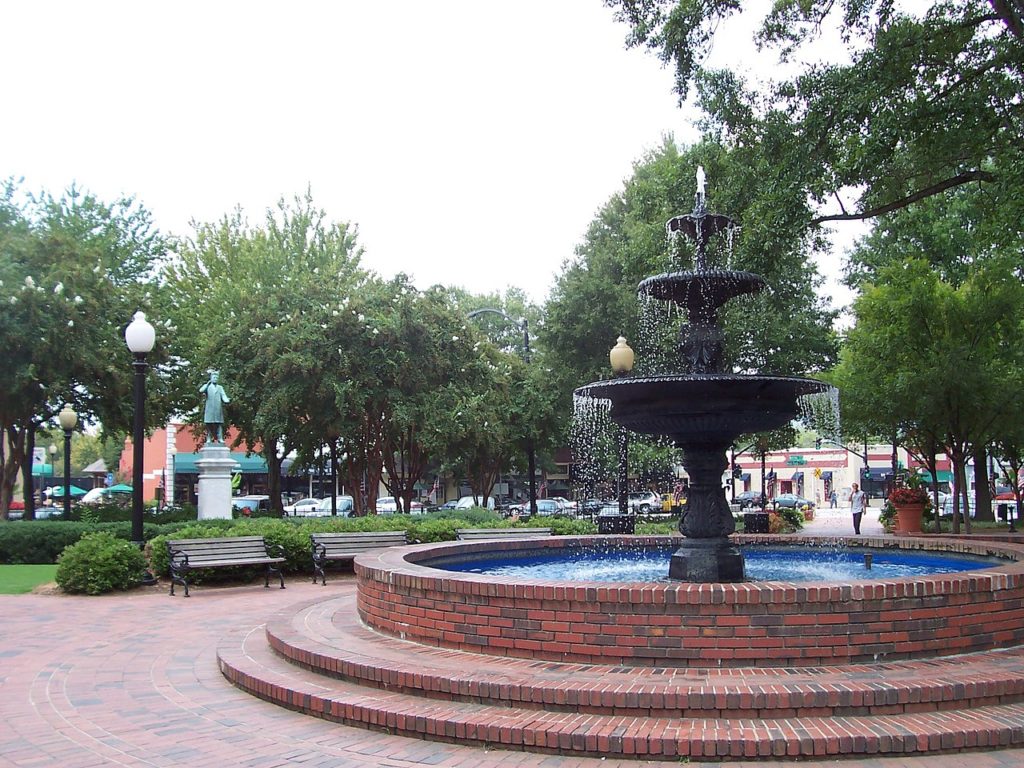 A round fountain, lined with bricks in the center of Marietta Square.