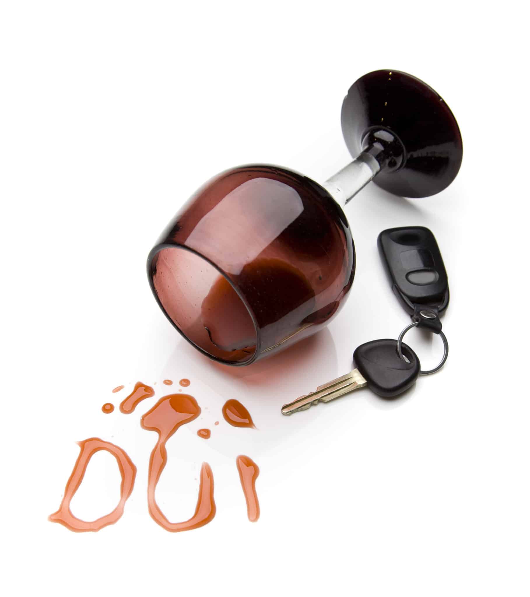 A wine glass on it's side with red wine spilled out in the shape of the letters DUI beside a car key.