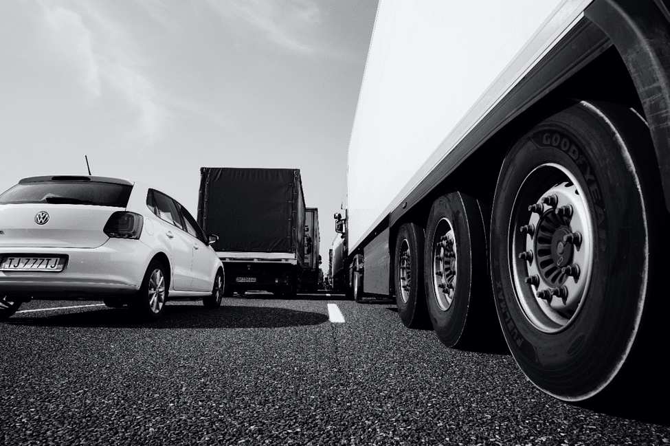 View from road of a car beside an 18 wheeler.