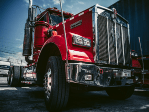 A large red truck parked under the clear blue sky.