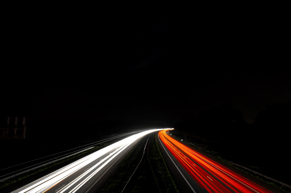 A blur of tailights and headlights of cars driving at night.