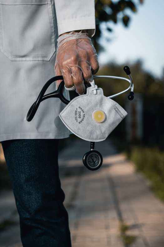 A doctor with a glove on their hand holding medical equipment.