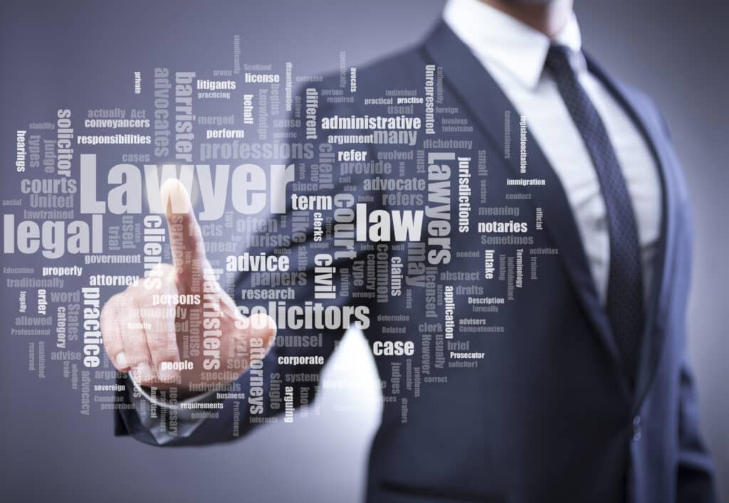 Blurry image of a man in a suit in the background pointing toward a collection of lawyer associated words in the foreground.