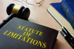 Legal book titled "Statute of Limitations" next to a gavel, law books, and a fountain pen on a lawyer’s desk in Kennesaw Georgia.