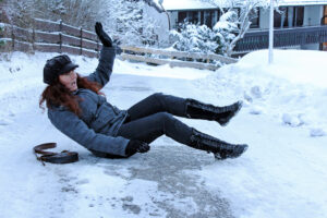 Woman slips and falls on an icy driveway.