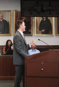 Professional male attorney standing at a podium addressing a judge.