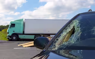 Damaged passenger vehicle and overturned semi-truck after a serious trucking accident on a Georgia highway.