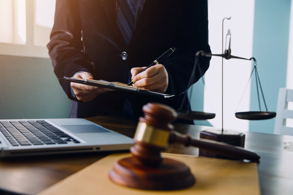 Businessman consulting with male lawyer or judge during team meeting, discussing client case, law and legal services concept.
