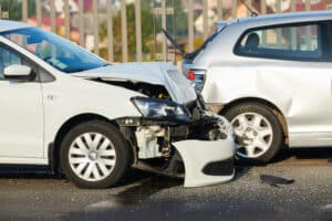 Car crash accident on the street with two damaged automobiles after a collision.